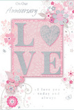 This anniversary card design captures the mood of enduring romance, not unlike the soft, pastel arrangements often delivered to homes around Gidea Park for special milestones. At its centre, the word LOVE is presented in gently raised lettering, coated in a fine, shimmering glitter that lends a subtle sense of luxury. The letter O is transformed into a sparkling heart motif, rendered in textured silver that glints against the softer pinks and whites around it. Surrounding this focal word, a cluster of delicate flowers opens outward, blending blush and mauve tones with hints of ivory, as though painted in watercolour. The petals appear light and flowing, their lines slender and graceful, evoking the care with which a florist curves each stem and leaf when preparing an anniversary bouquet. Small details-scattered petals, swirling tendrils, and discreet butterfly shapes-add motion and whimsy, recalling the feel of a gentle spring breeze through a Gidea Park garden. The background palette of pastel pink and soft grey keeps the design calm and intimate, letting the silver accents and glitter catch the light without overwhelming the senses. Above and below the central motif, simple, elegant script reads phrases like On Our Anniversary and I love you today and always, the lettering modest yet heartfelt. The entire card feels like a keepsake, the paper equivalent of a favourite arrangement that has come to symbolise years of shared life, and would sit beautifully alongside flowers chosen with care from a trusted local Gidea Park florist.